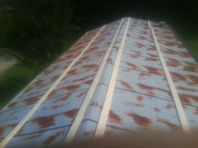 Rusted metal roof panels with new wood purlins before replacement — Storm Damage Roof Repair in Superior by Roofing Brothers