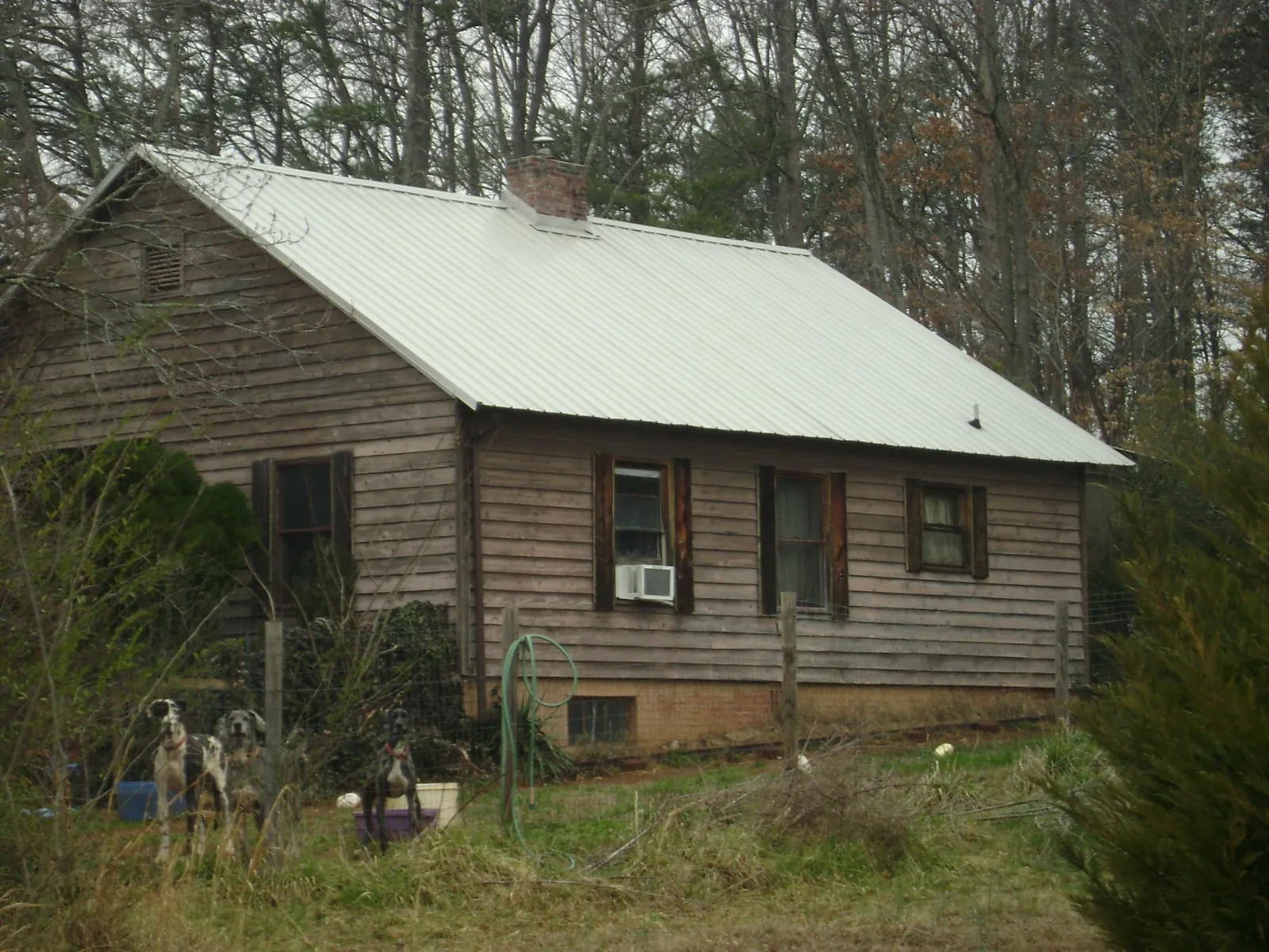 White metal roof on an old wood sided farmhouse, from a Metal Roof Installation job in Superior